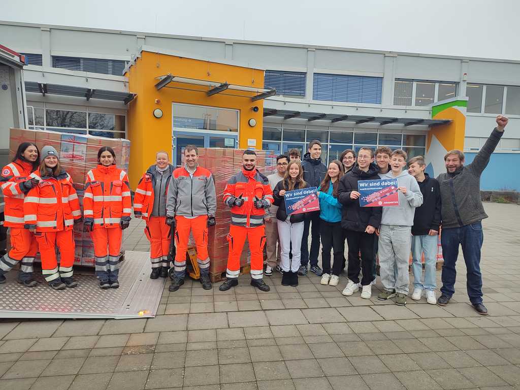 Schüler und Schülerinnen bei der Übergabe von Hilfspaketen an die Weihnachtstrucker.