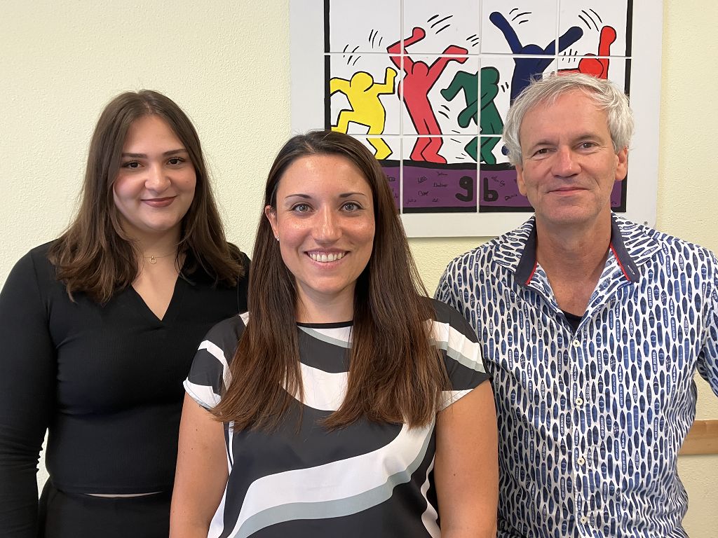 Schulsozialarbeiter stehen vor einem Bild im Spieleraum